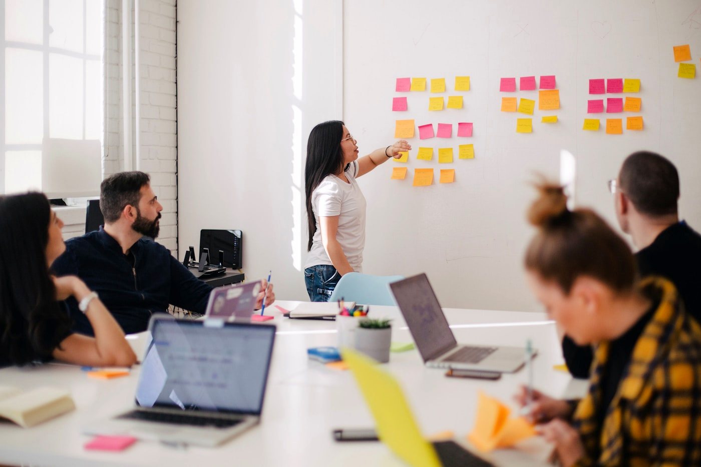 Sesión de diseño con post-its y equipo multidisciplinario mapeando un proceso del cliente