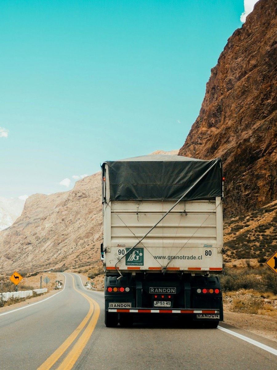 Tractocamión de carga avanzando por carretera de montaña, gestionado con PyP Cargo